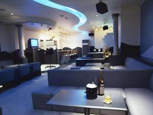 a room with blue lights and couches and a table at Hotel Resea Minamichita in Minamichita