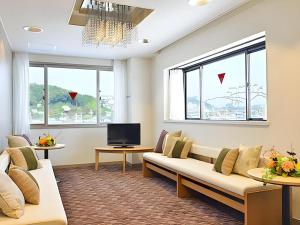ein Wohnzimmer mit Sofa und Fernseher in der Unterkunft Hotel Ligare Kasugano in Nara