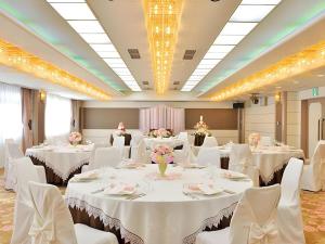 ein Bankettsaal mit weißen Tischen und weißen Stühlen in der Unterkunft Hotel Ligare Kasugano in Nara