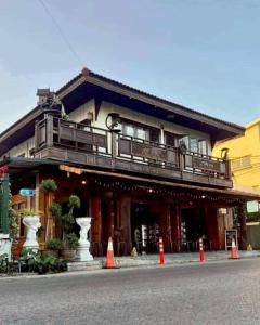 een gebouw met een balkon en oranje kegels ervoor bij Uncle Matts Cafe and Chill in Ban Yang Pa Kha