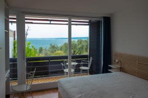 莫尼加Casa dei limoni Steps to Garda Lake的一间带床的卧室和一个可欣赏美景的阳台