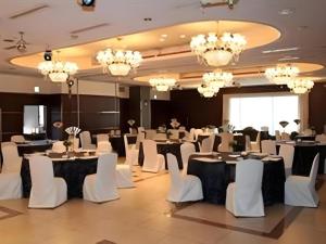 a banquet hall with white tables and white chairs at Hotel Ito in Nishi-sakamoto
