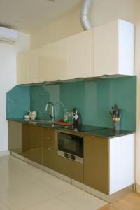 a kitchen with green and white cabinets and a sink at The Hideout Stay in Hanoi +42 photos