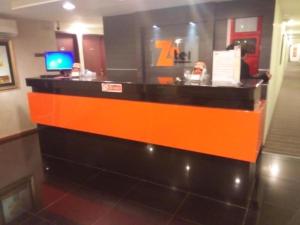 an orange and black reception desk in a restaurant at Zotel Business & Leisure Hotel in Kampong Tabuan