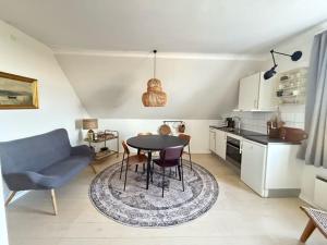 a living room with a table and a kitchen at Villa Koch X Pension Koch in Gudhjem