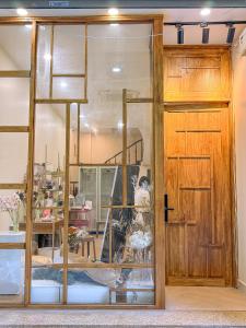 ein Schaufenster eines Ladens mit einer Holztür in der Unterkunft The Hideout Stay in Hanoi