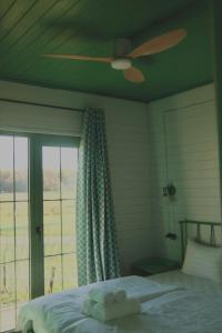 1 dormitorio con ventilador de techo y 1 cama con ventana en Chateau Vartsikhe, en Varts'ikhe