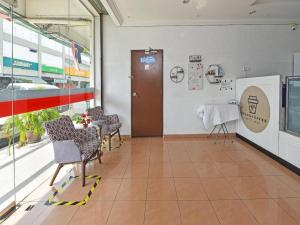 a waiting room with chairs and a table in a building at OYO 90559 Ummul Motel C Mart in Arau