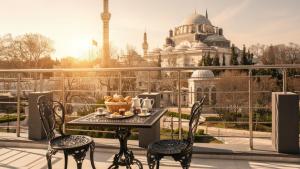 una mesa y sillas en un balcón con vistas a una mezquita en XLoft, en Estambul