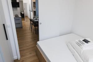 a bedroom with a bed and a dining room at POPIELATE Apartamenty in Żywiec