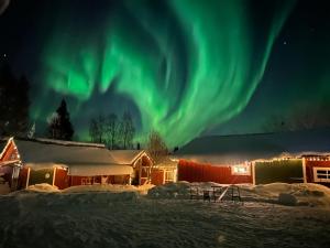 an image of the aurora borealis over a lodge at Marlens mysiga B&B in Pålänge