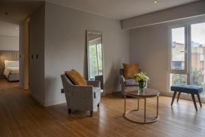 Una sala de estar con dos sillas y una mesa. en NH Boulevard del Río Cali, en Cali