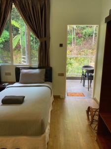 a bedroom with a bed and a large window at Highlanders Garden Guesthouse at Arundina Cameron Highlands in Cameron Highlands +221 photos