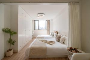 zwei Betten in einem Schlafzimmer mit weißen Wänden in der Unterkunft HuanYu in Shanghai