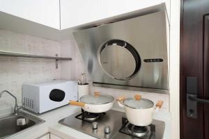 eine Küche mit zwei Töpfen auf einem Herd mit Mikrowelle in der Unterkunft HuanYu in Shanghai + 22 Fotos