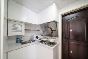 eine Küche mit weißen Schränken und einem Herd mit 2 Töpfen in der Unterkunft HuanYu in Shanghai