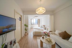 ein Wohnzimmer mit einem Sofa, einem Bett und einem TV in der Unterkunft HuanYu in Shanghai