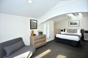 1 dormitorio con 1 cama y 1 sofá en Southwark Hotel & Apartments, en Christchurch