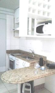 a kitchen with a counter and a sink and a microwave at #Flats Studio 45 Bueno Oeste in Goiânia