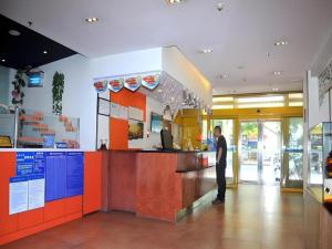 a man standing at the counter of a fast food restaurant at 7 Days Premium Zibo Jinjing Avenue the Mixc in Zibo