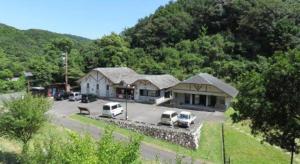 uma vista aérea de uma casa com carros estacionados num parque de estacionamento em Hotel Bellreef Otsuki em Komame