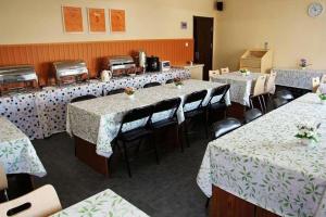 une rangée de tables dans un restaurant avec une nappe blanche dans l'établissement 7 Days Inn Qingdao Haier Zone Ditie Tower Jiushui West Road, à Laoshan