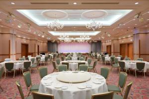 a banquet hall with tables and chairs and chandeliers at Grand Hotel New Oji in Ōjimachi