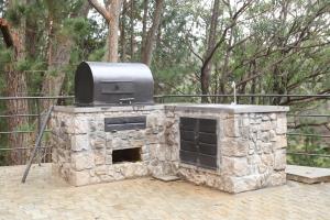 a stone fireplace with a tv on top of it at Lake House Mantasoa in Mantasoa