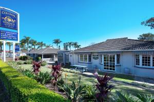 een huis met een bord ervoor bij Colonial Terrace Motor Inn in Raymond Terrace