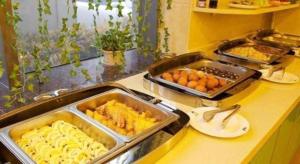 a kitchen with trays of food on a counter at GreenTree Inn Hefei Huangshan Road Business Hotel in Hefei