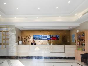 a woman standing behind a counter in a store at GreenTree Inn Suzhou North Zhongshan Road Weiye Yingchun Plaza Business Hotel in Suzhou