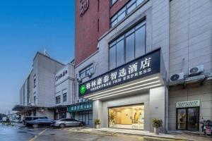 a store with a sign on the side of a building at GreenTree Inn Suzhou North Zhongshan Road Weiye Yingchun Plaza Business Hotel in Suzhou