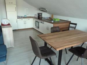 una cucina con tavolo e sedie in legno di Haus Bergblick 1 a Utzmemmingen