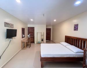长滩岛Boracay Amor Apartment (Garden)的一间卧室，里面有一张床和一台平板电视