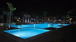 ein großer blauer Pool in der Nacht in der Unterkunft Apartment in Guardamar del Segura, El Raso, Oasis Beach X in Guardamar del Segura
