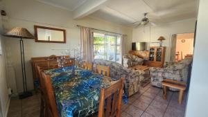 una sala de estar con una mesa y un sofá en Jakaranda Haven, en Velddrif