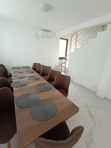 a conference room with a long wooden table and chairs at Casa Venus in Sînmartin