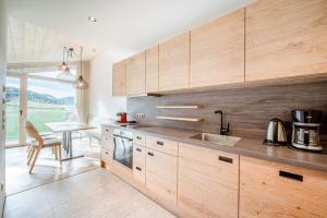 a kitchen with wooden cabinets and a table with a dining room at Harmls Aparthotel in Flachau