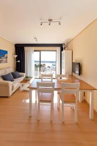 a living room with a table and chairs and a couch at Apartamentos Port Cambrils in Cambrils