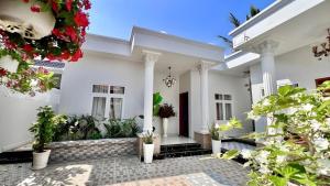 a white house with potted plants in the courtyard at Hoang Mai Hotel in Ấp Thanh Sơn (1)