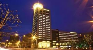 a tall building with lights on top at night at Chutian Guangdong International Hotel in Wuhan