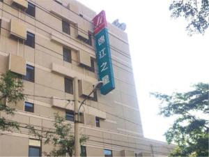 a building with a street sign in front of it at Jinjiang Inn Shenyang Zhongshan Square Medical University First Hospital in Shenyang