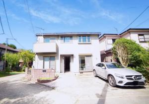 ein Auto, das vor einem weißen Haus parkt in der Unterkunft Route 99 Sengokuhara in Sengokuhara