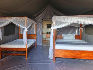 a bedroom with two beds in a tent at Endeem mara resort in Ololaimutiek