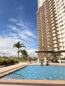 a large swimming pool with two people in a building at Emetheria Residence CDO in Cagayan de Oro