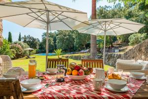 a table with a bowl of fruit and two umbrellas at Can Perot - Pollença in Pollença