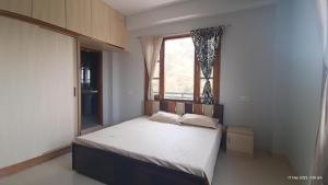 a bedroom with a large bed with a window at Amar Janki Hill Cottage in Shimla Airport