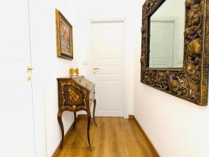 Habitación con silla y espejo en la pared. en ComeCasa Langhe Garden House-Pace e Panorama a Benevello, en Benevello 22 fotos más