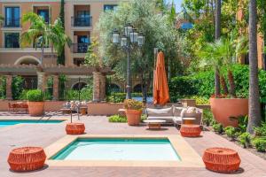 a pool at a hotel with chairs and an umbrella at Modern 2BR Cozy Apartment in Irvine in Lake Forest