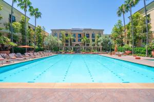 a large swimming pool with chairs and a building at Modern 2BR Cozy Apartment in Irvine in Lake Forest